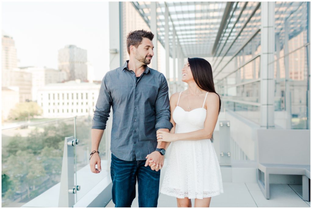 An engaged couple posing on top of the Hilton Hotel for their downtown Cleveland engagement session