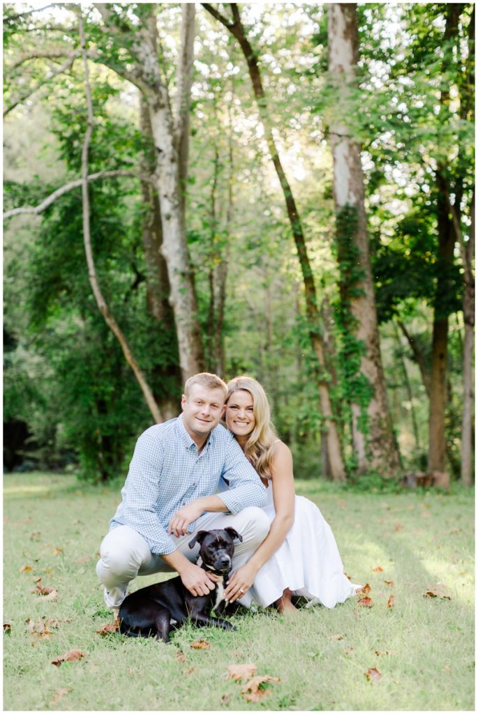 engaged couple with their dog posing for their chagrin falls engagement session