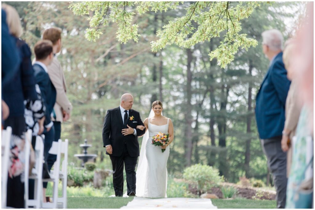 a bride walking down the isle with her father on her wedding day 