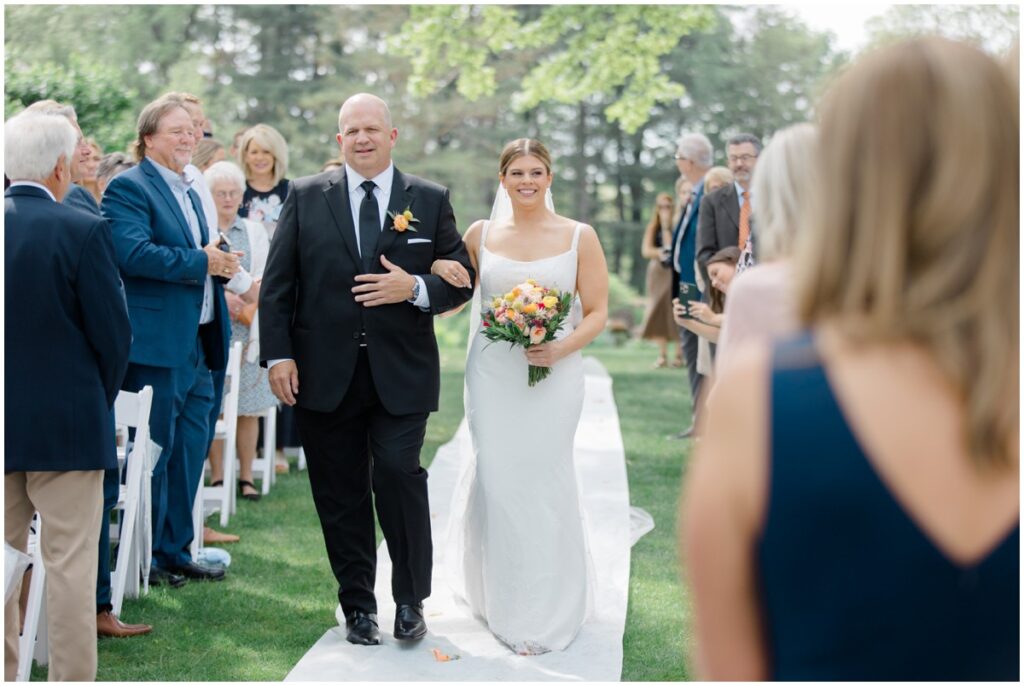 a bride walking down the isle with her father on her wedding day