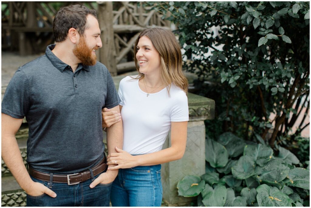 An engaged couple looking at each other and smiling during their downtown chagrin falls engagement session
