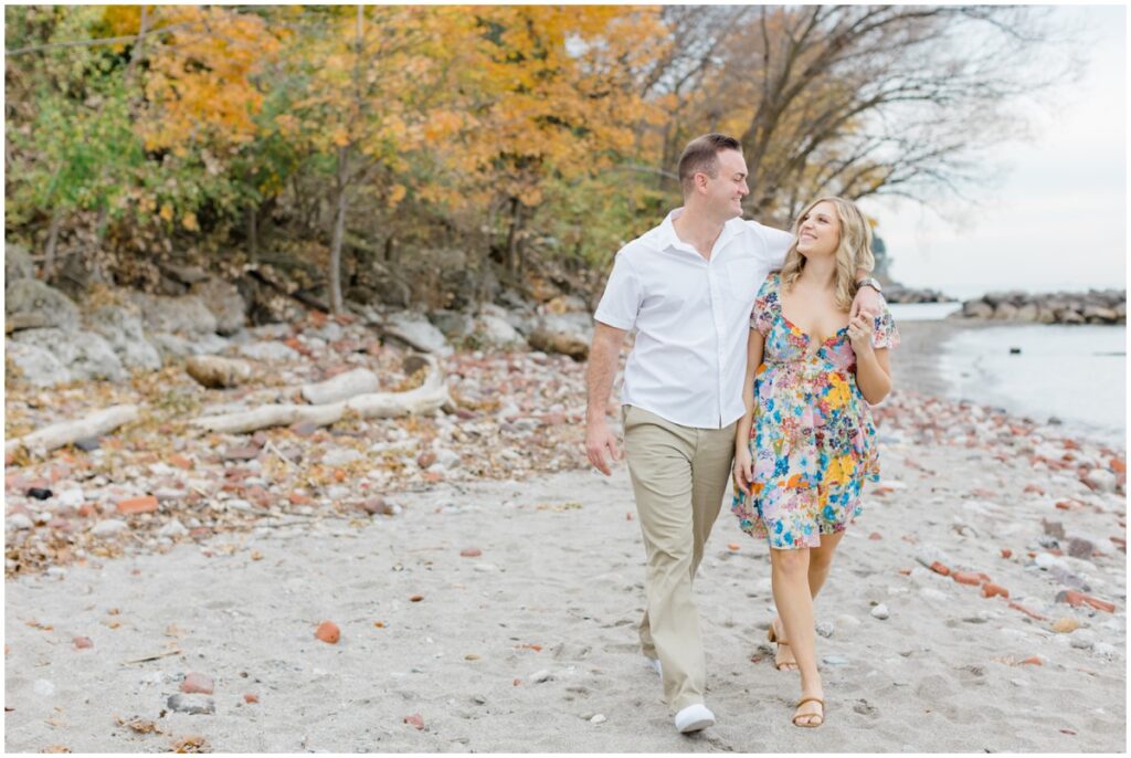 An engaged couple walking along Edgewater park for their engagement session